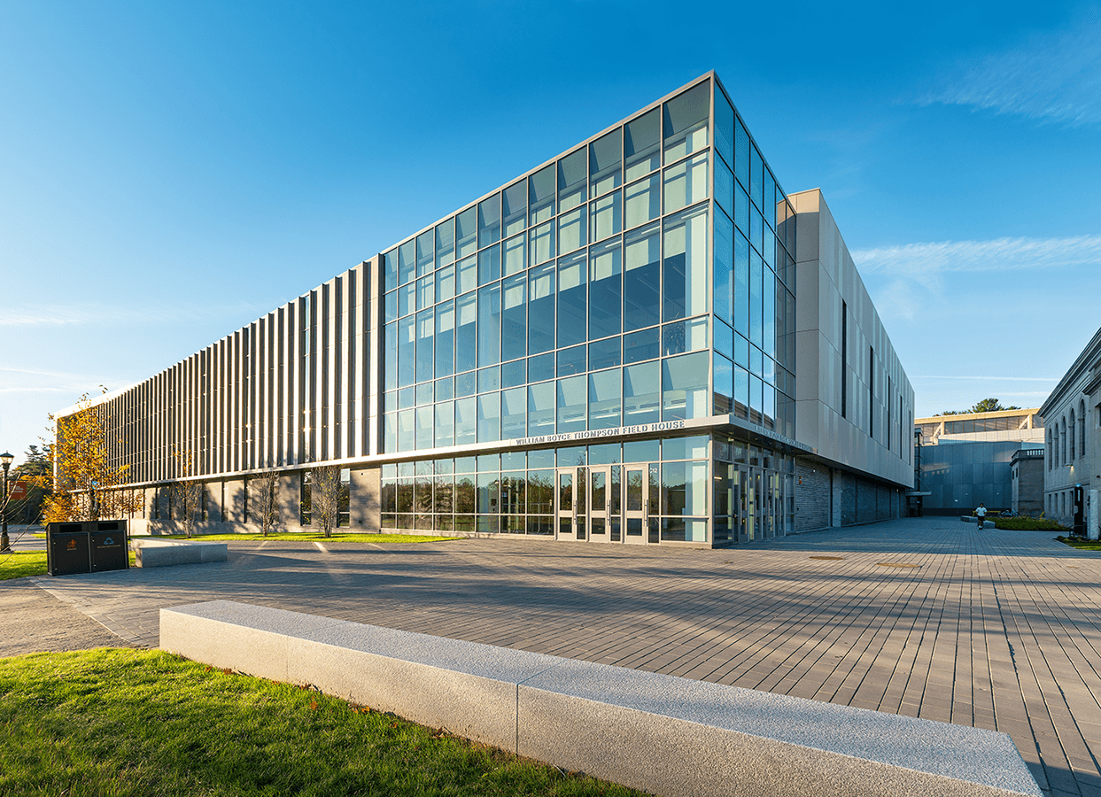 A large building with a lot of windows and a brick walkway in front of it.