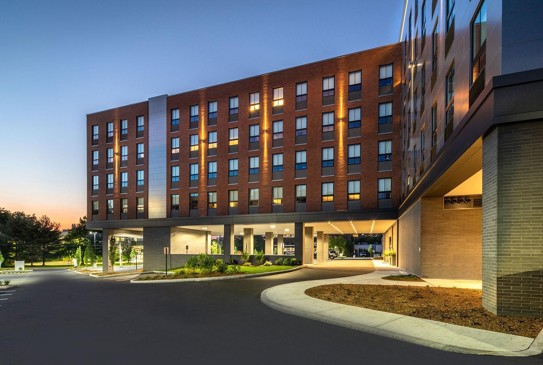 A large brick building with a lot of windows is lit up at night.
