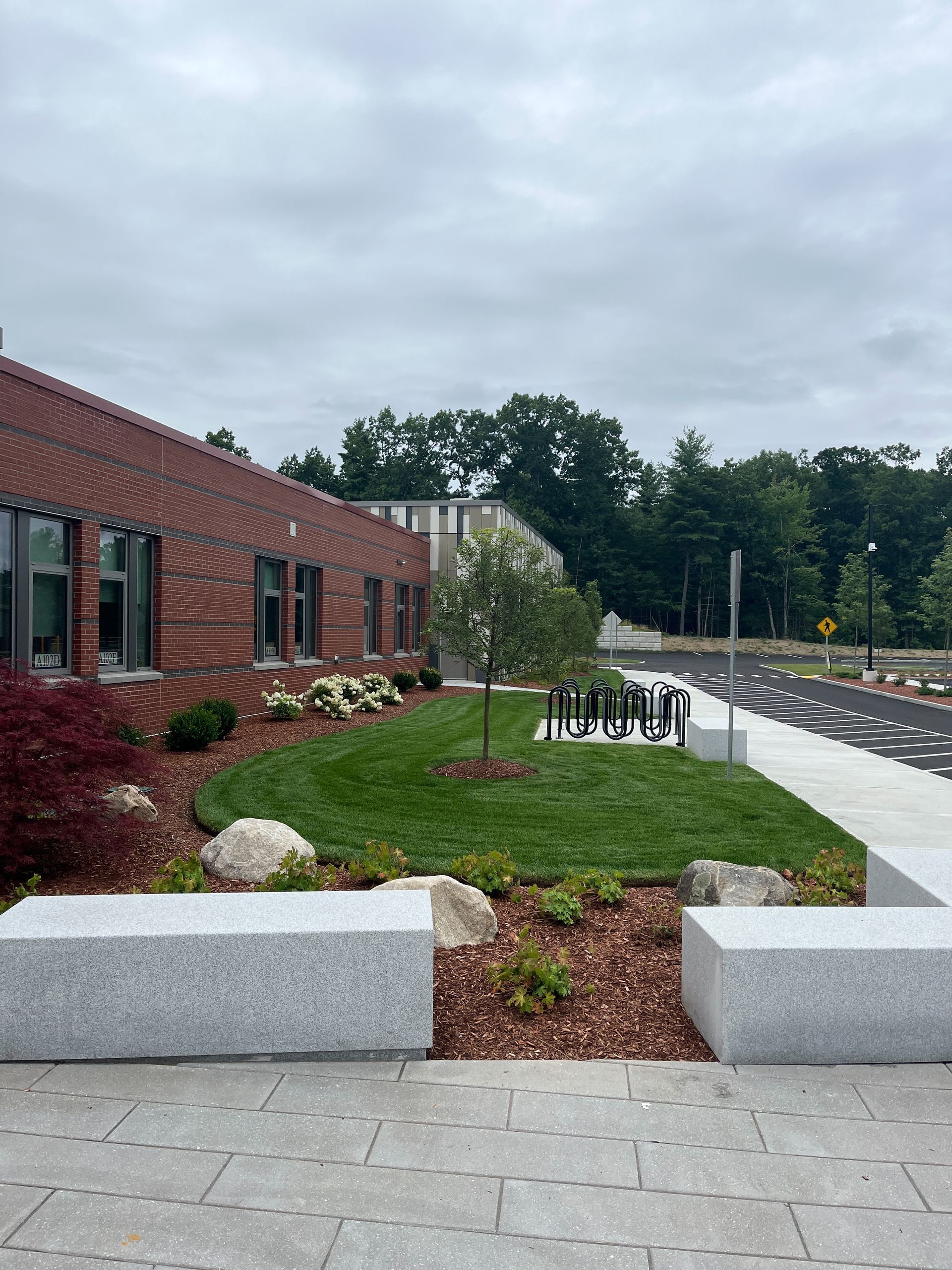 A brick building with a lush green lawn in front of it.
