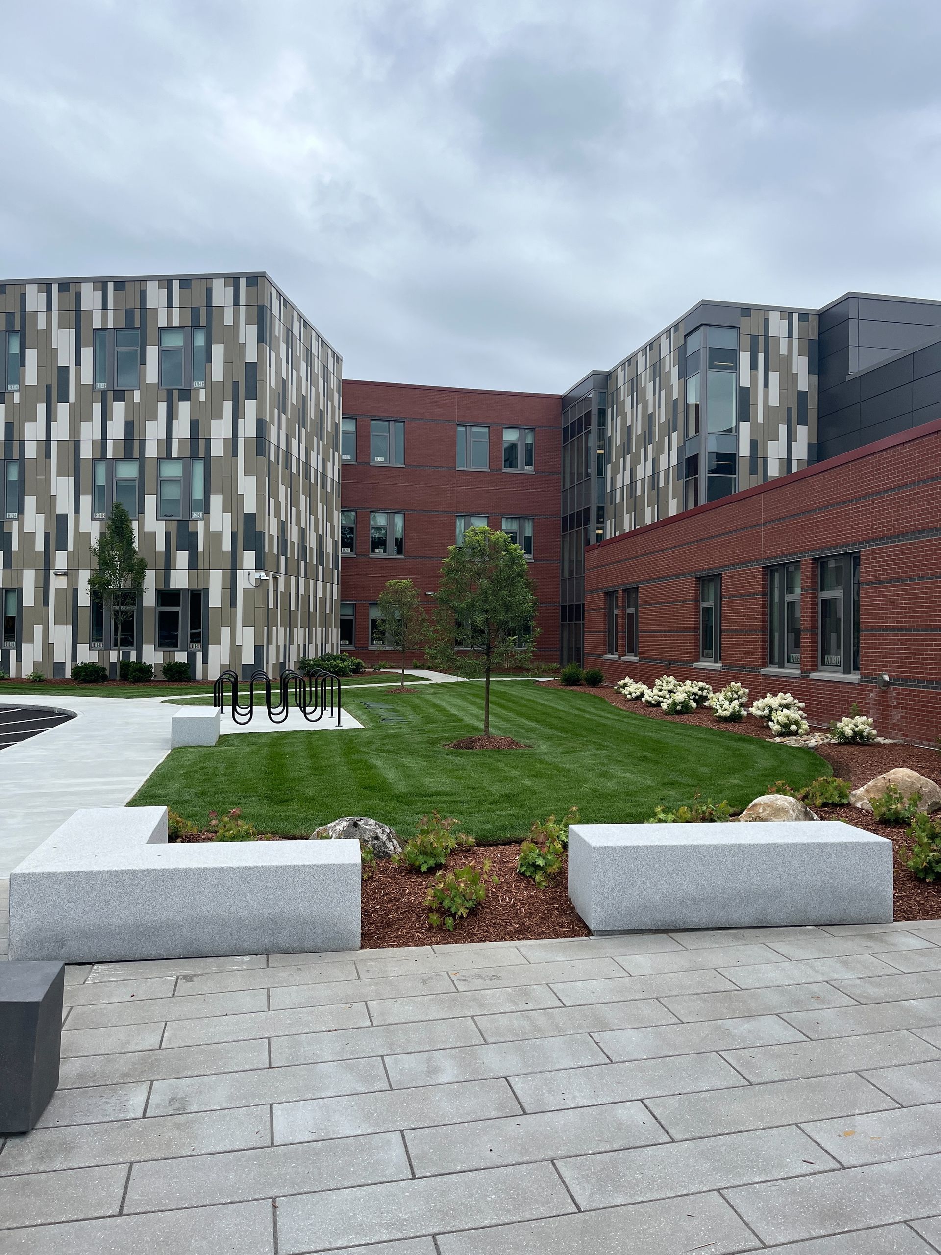 A large brick building with a lush green lawn in front of it.