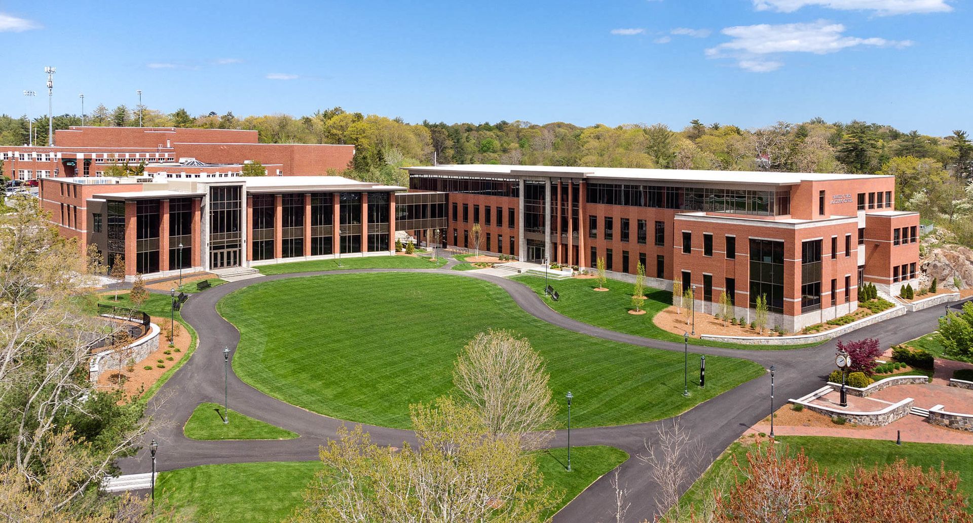An aerial view of a large brick building surrounded by grass and trees.