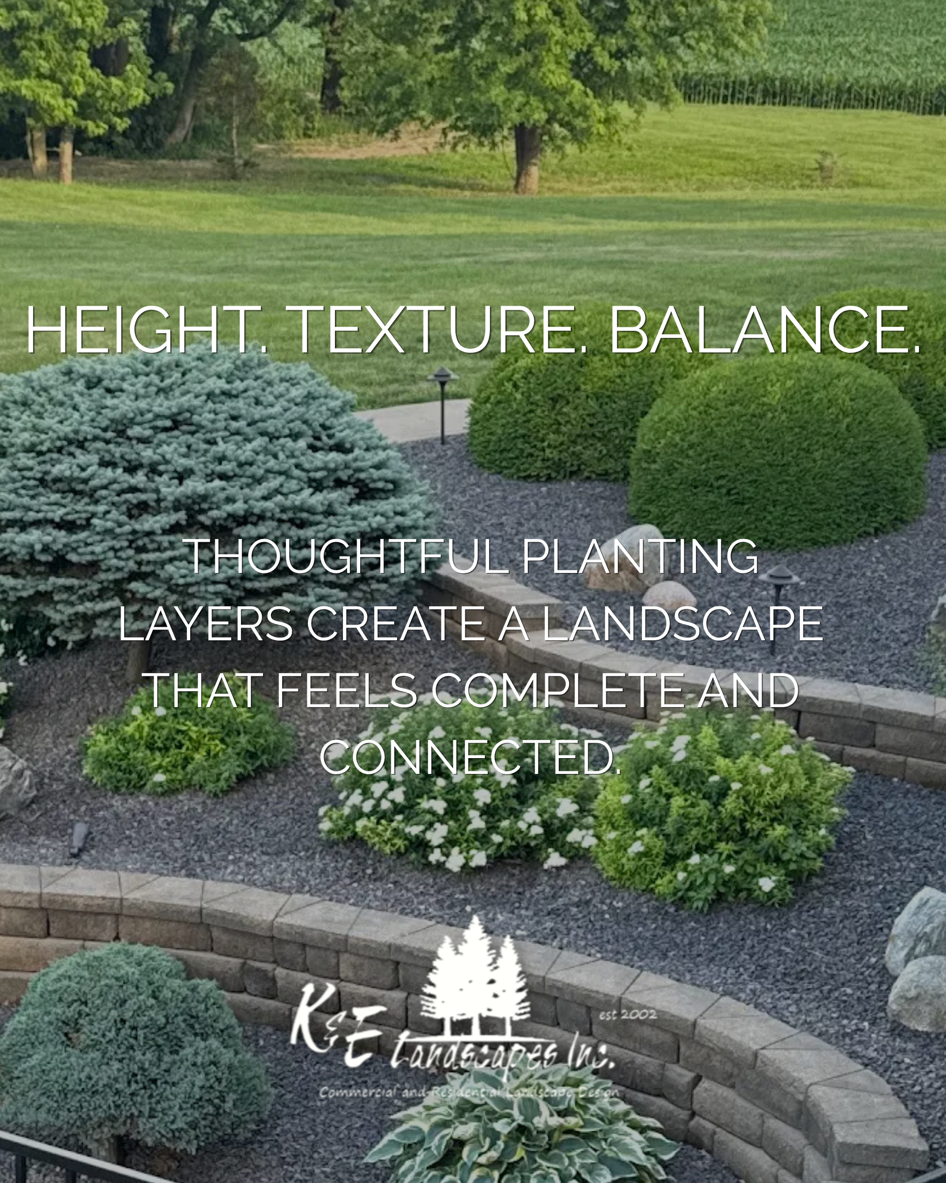 Layered landscape design by K&E Landscapes, Inc., featuring evergreen shrubs, flowering plants, and curved retaining walls in Southeast Iowa.