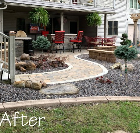 Patio and garden landscape with curved stone walkway, red chairs, and hanging plants