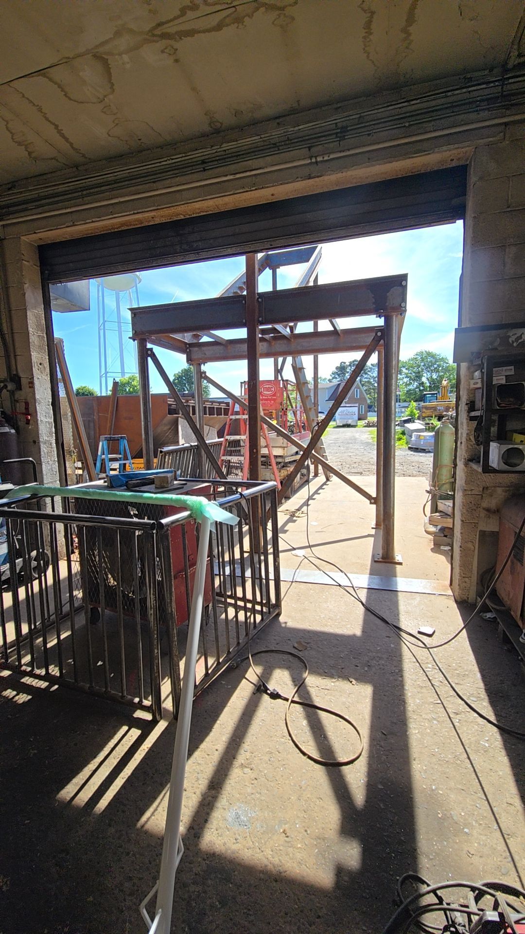 Steel framework construction visible through an open garage door.