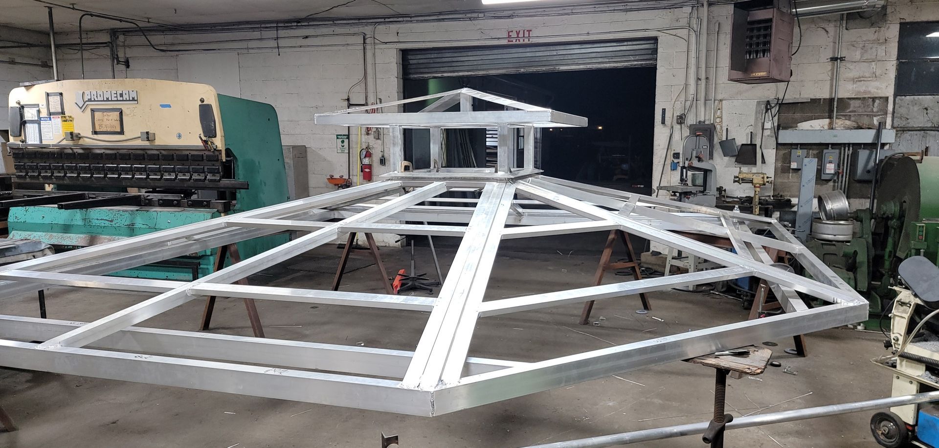Metal structure frame in a workshop, possibly for a roof or gazebo.