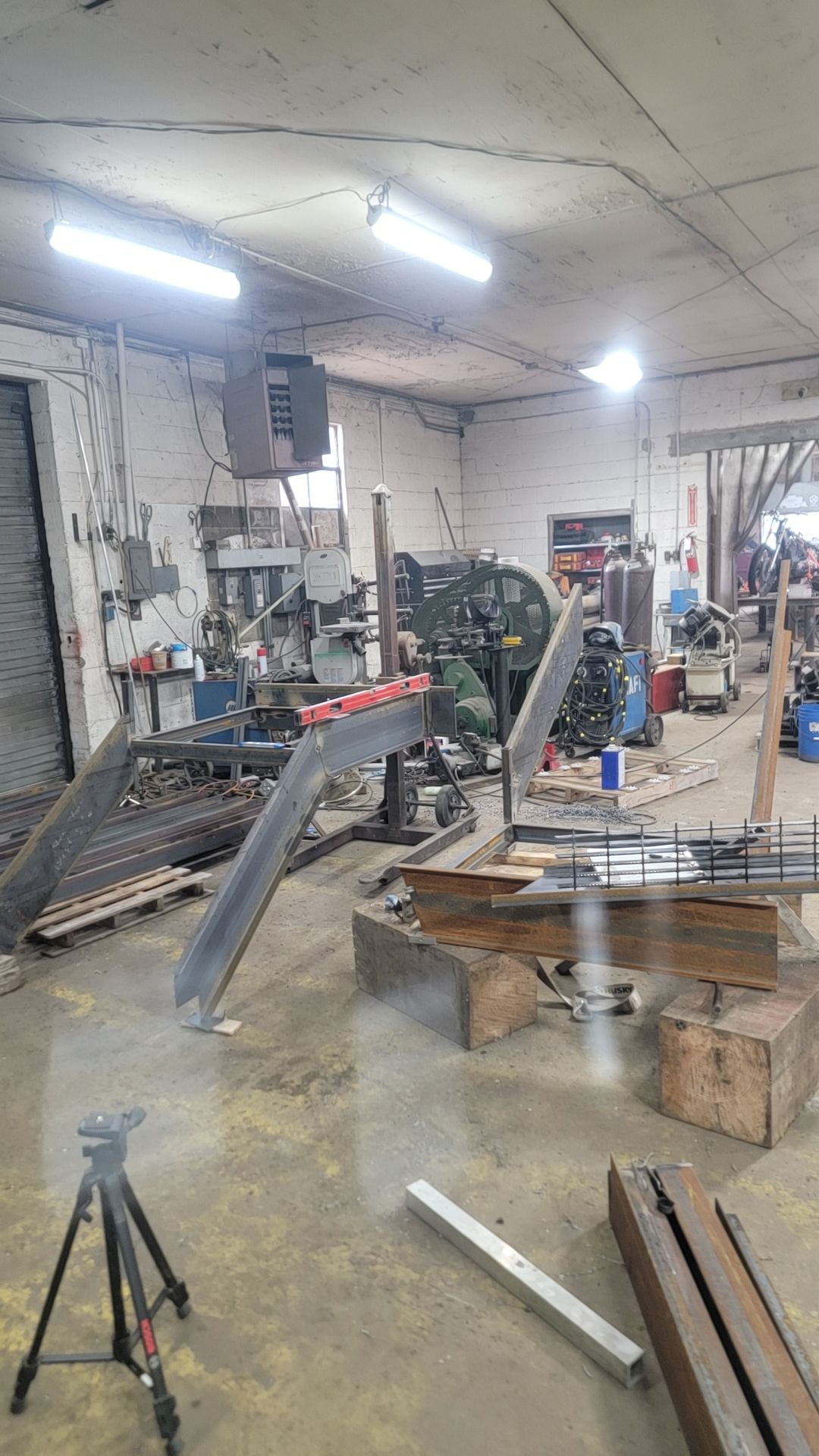 Workshop interior with metalworking equipment; steel beams on floor.
