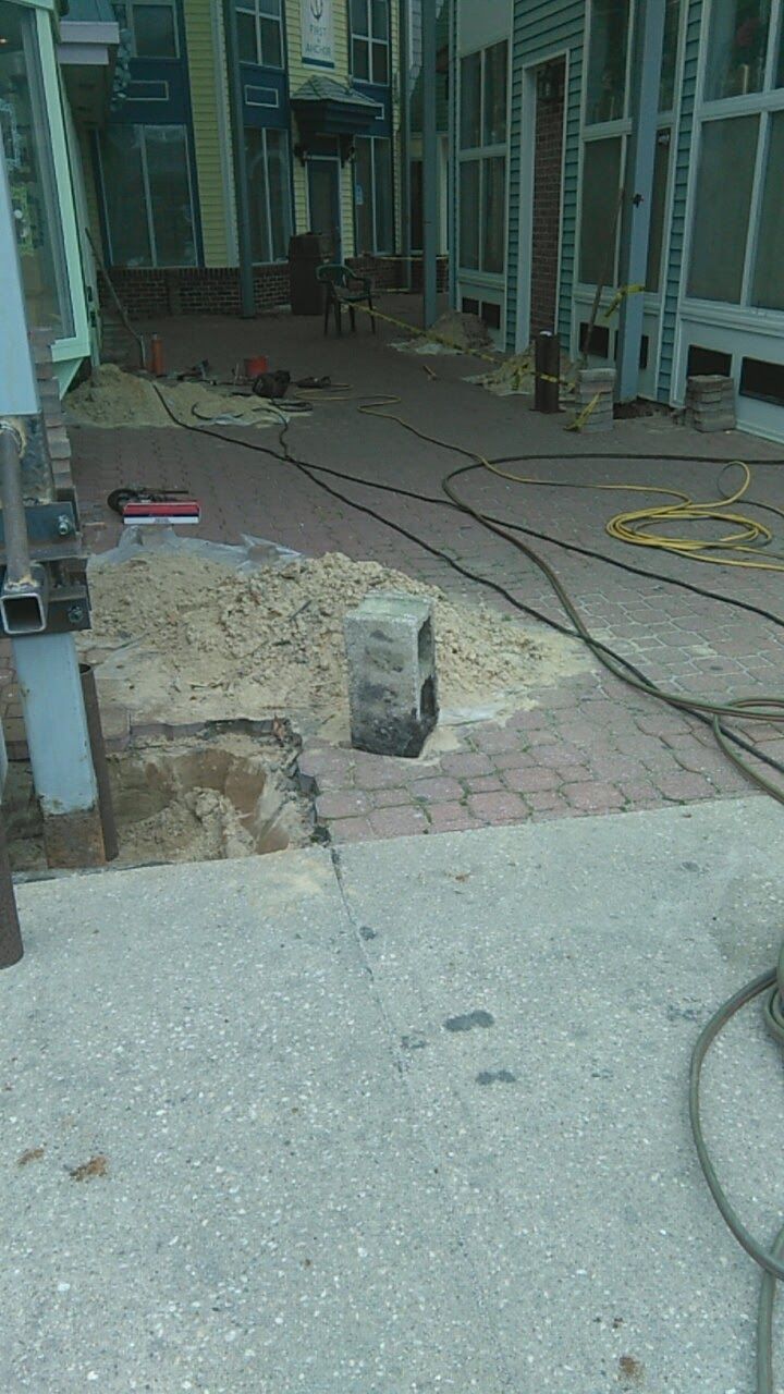 Construction site; walkway with exposed brick, concrete, and equipment.