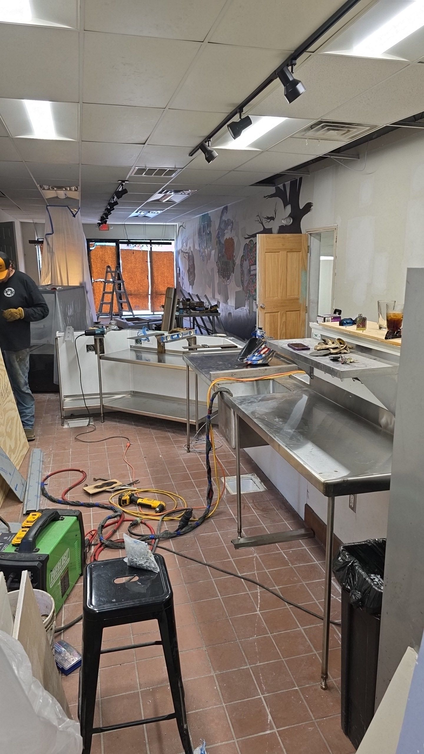 Interior of a commercial space under renovation with tools and construction materials.