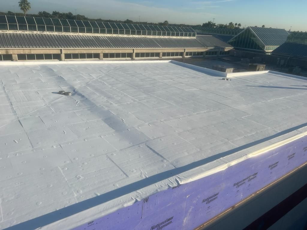 A large white roof with a lot of solar panels on it.