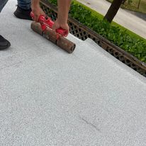 A person is using a roller on a concrete surface.