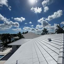 A white roof with a blue sky and clouds in the background.