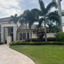 A large house with a lot of palm trees in front of it.