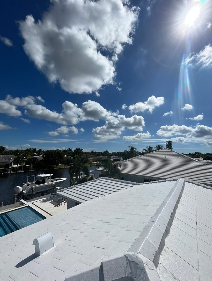A white roof with a blue sky and clouds in the background