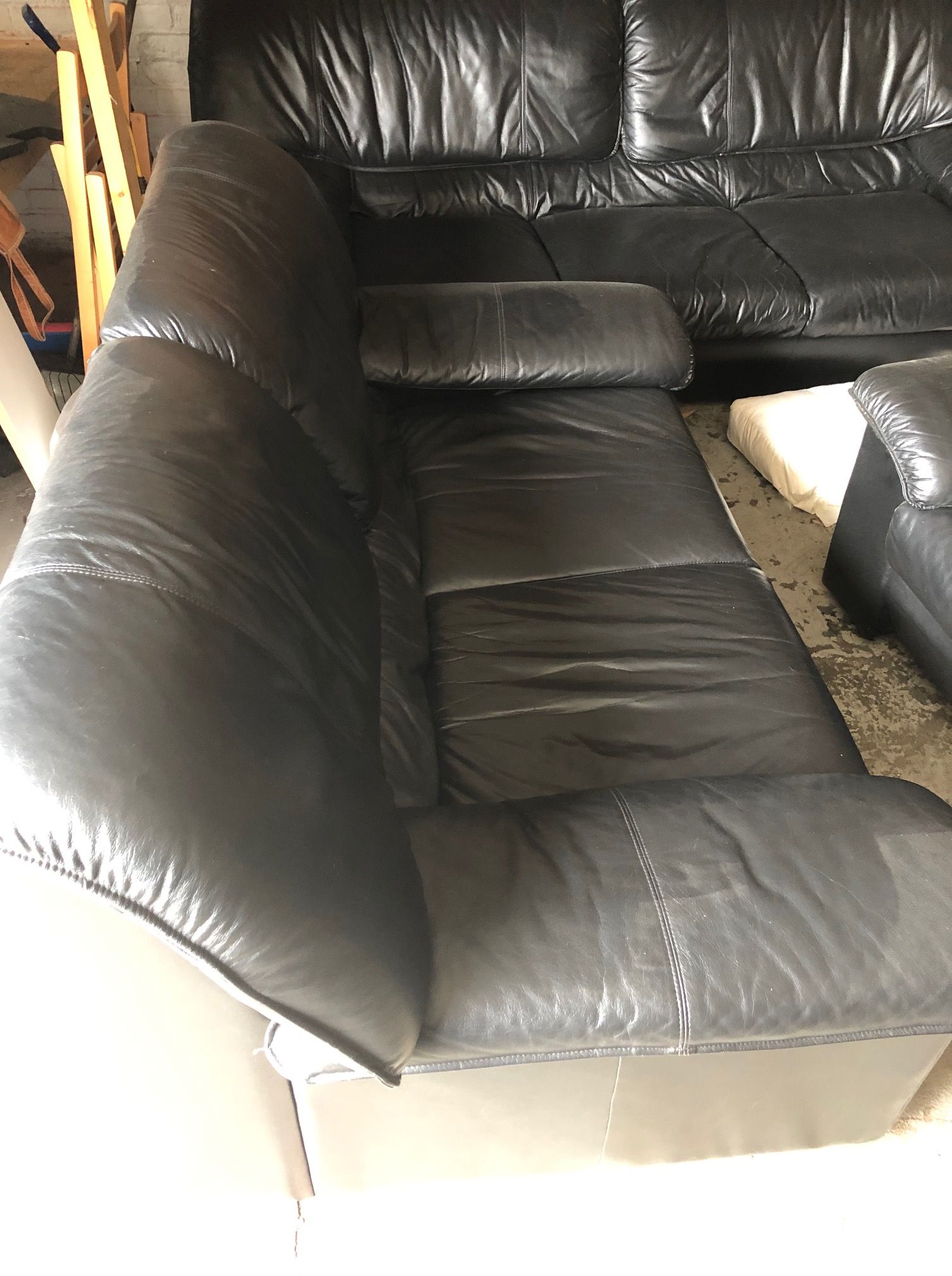A black leather sectional couch is sitting in a living room.