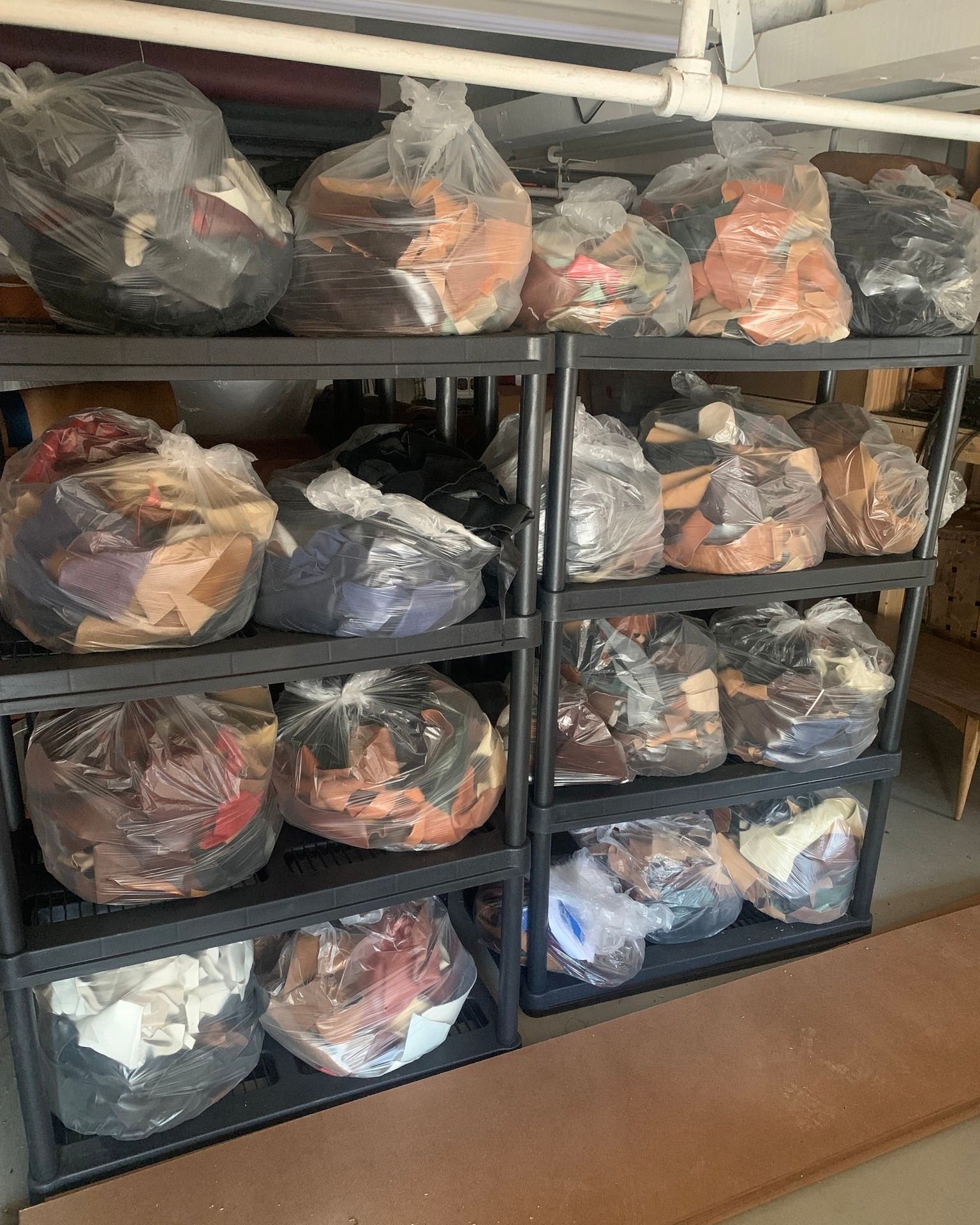 There are many bags of clothes on the shelves.
