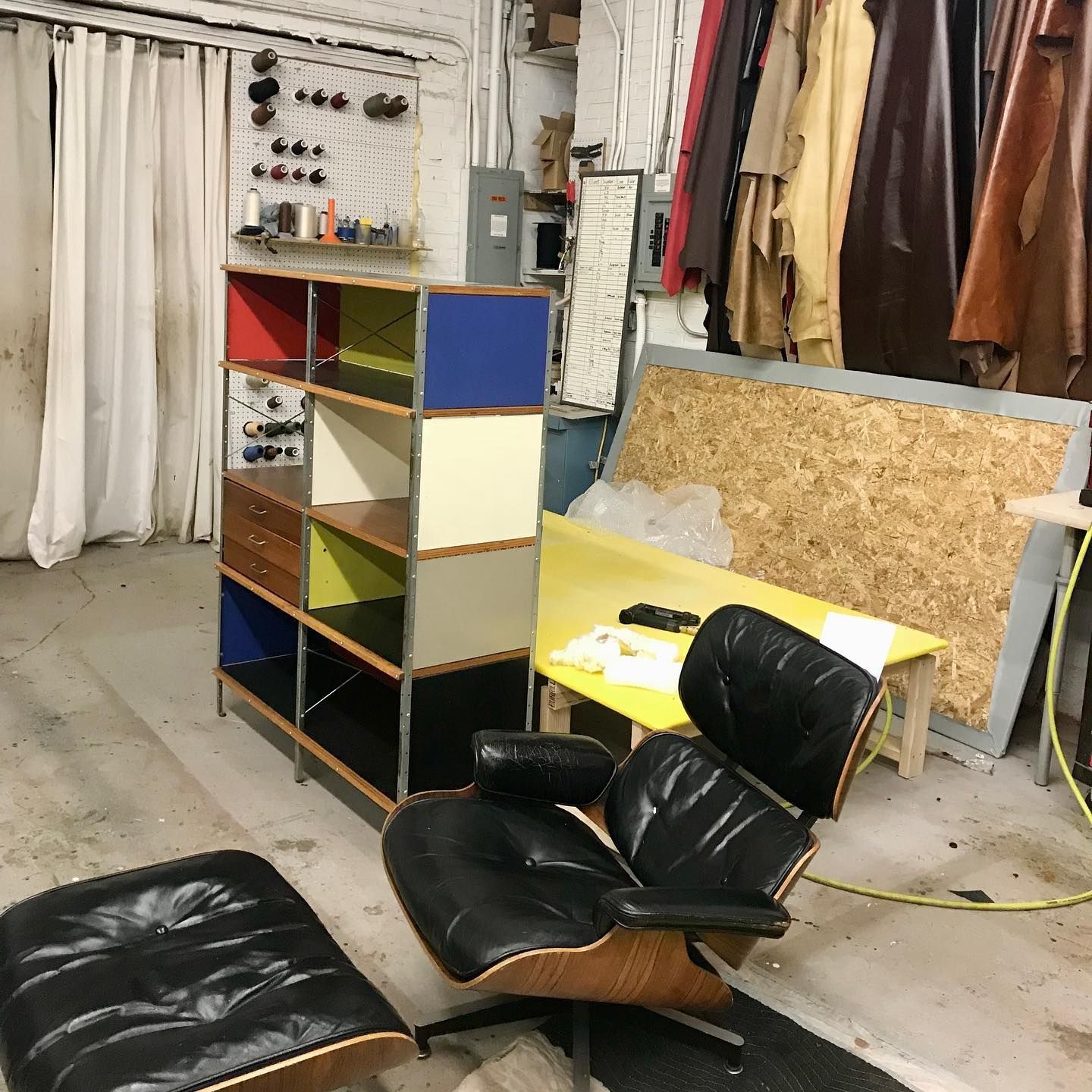 A room with a chair and ottoman in it