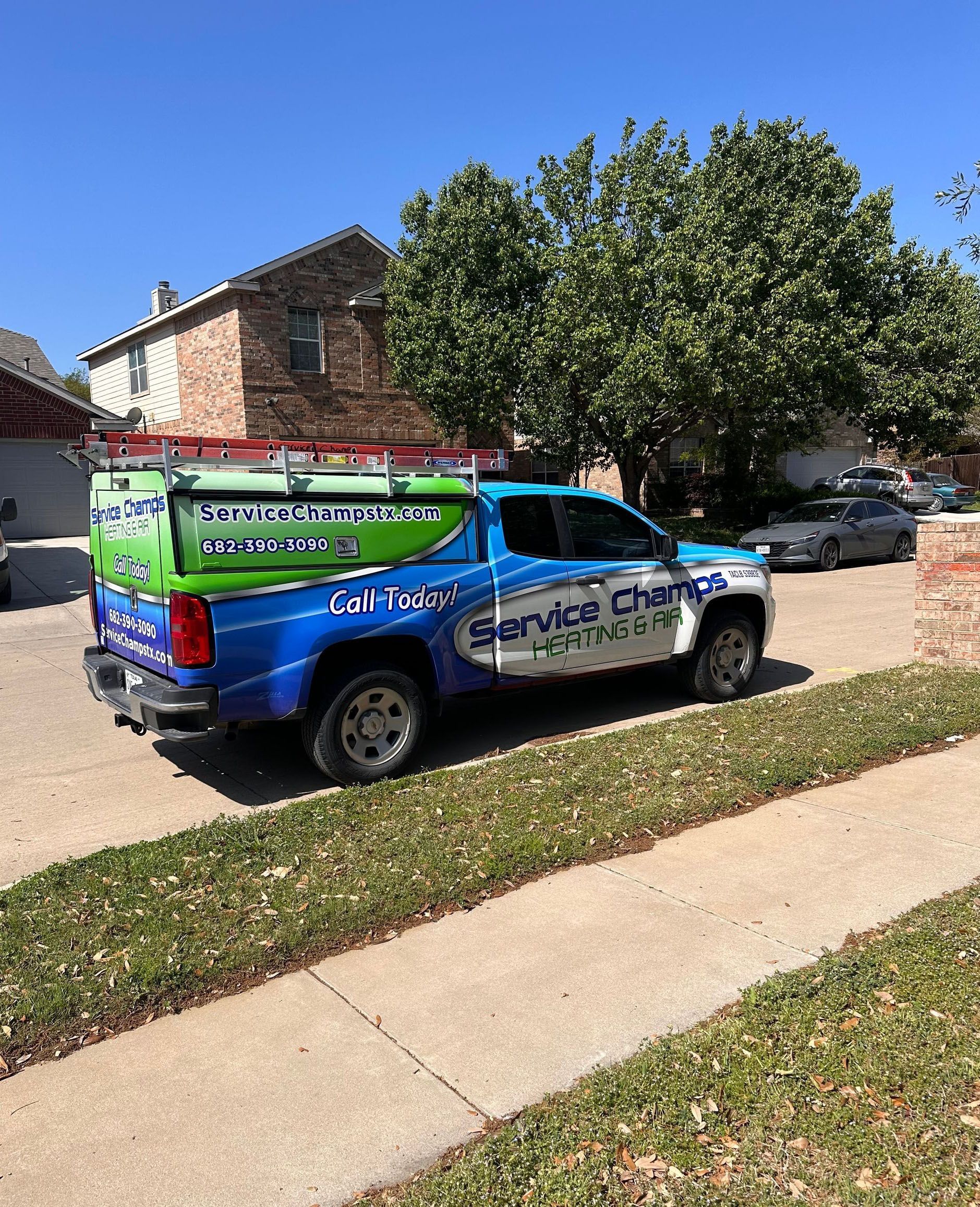 Blue Service Champs truck parked in front of a house.