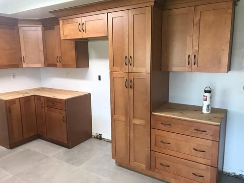 Kitchen cabinets, light brown wood, installed. Countertop and open space for appliances.