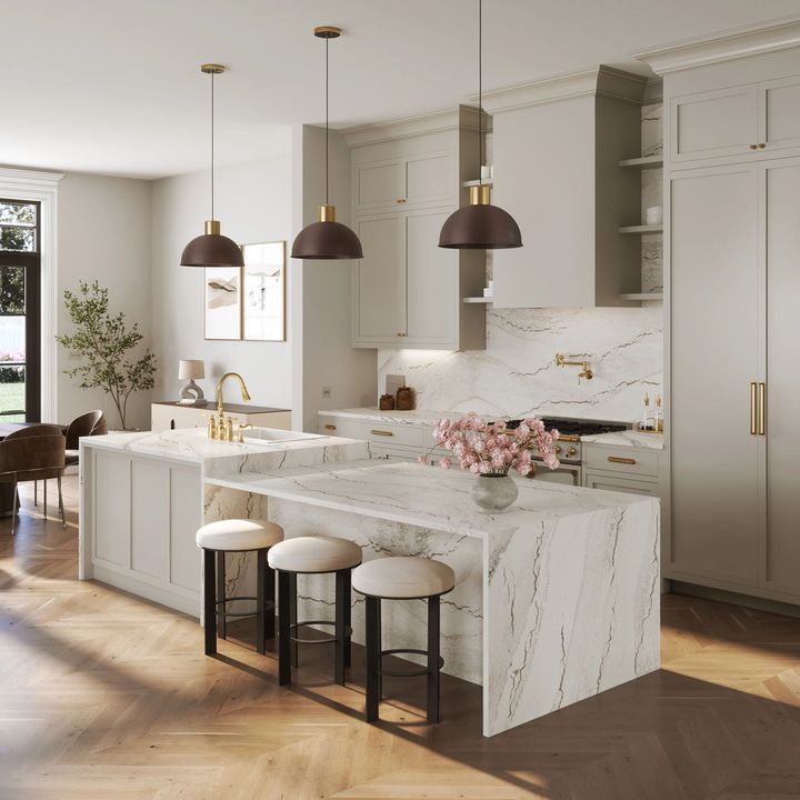 Modern kitchen with marble countertops, wood floors, and pendant lights.