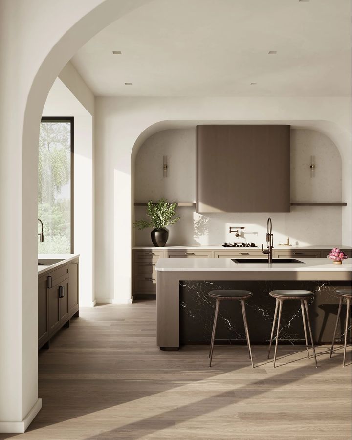 Modern kitchen with arched doorways, island seating, wood floors, and neutral tones.