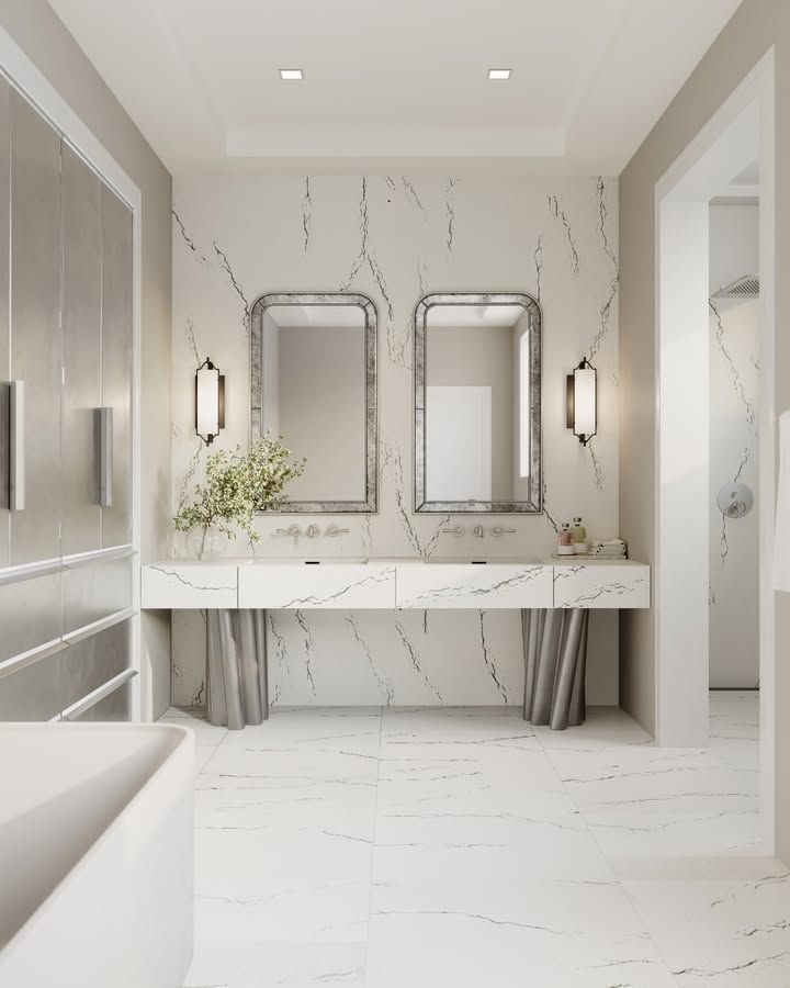 Elegant bathroom with marble walls and countertops, dual mirrors, and modern fixtures.