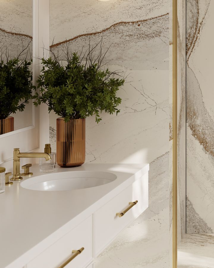 Modern bathroom with white countertop, copper vase with greenery, gold fixtures, and patterned wall.