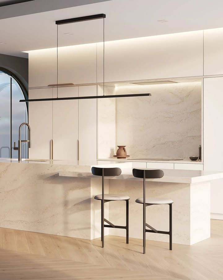 Modern kitchen with island, pendant lights, and bar stools. Soft, neutral color palette.