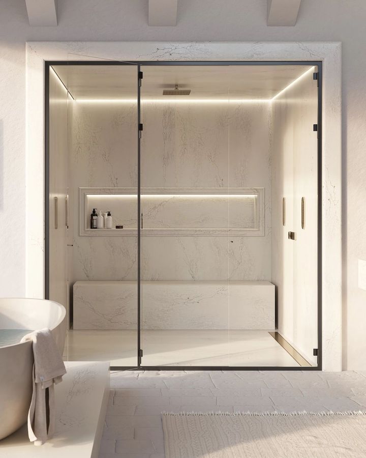 Modern shower enclosure with glass doors, black frame, and built-in bench.