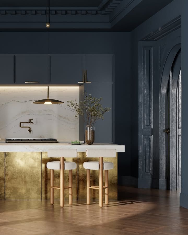 Modern kitchen with gold island, white stools, and blue walls.