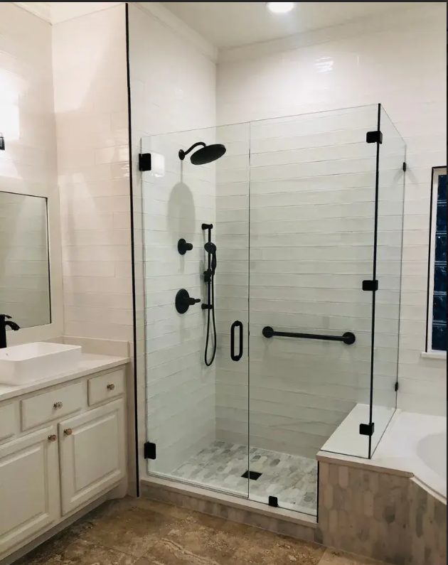 Modern bathroom featuring a frameless glass shower enclosure with matte black fixtures and a built-in bench seat.