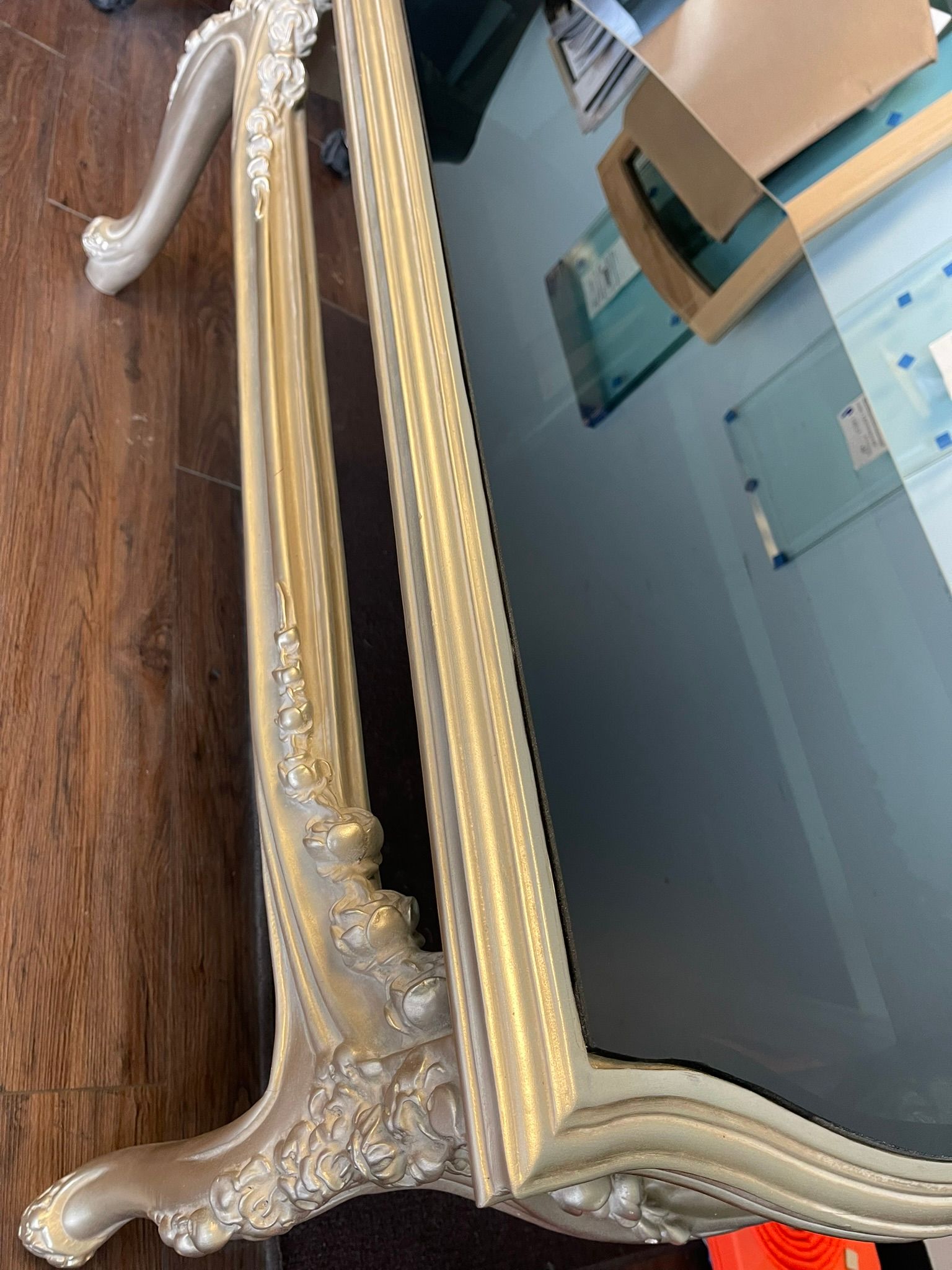 An ornate, champagne-colored wooden table with intricate floral carvings, seen from a high-angle perspective.