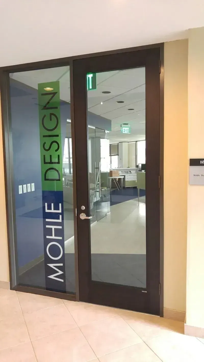 A glass door with a dark frame marked 