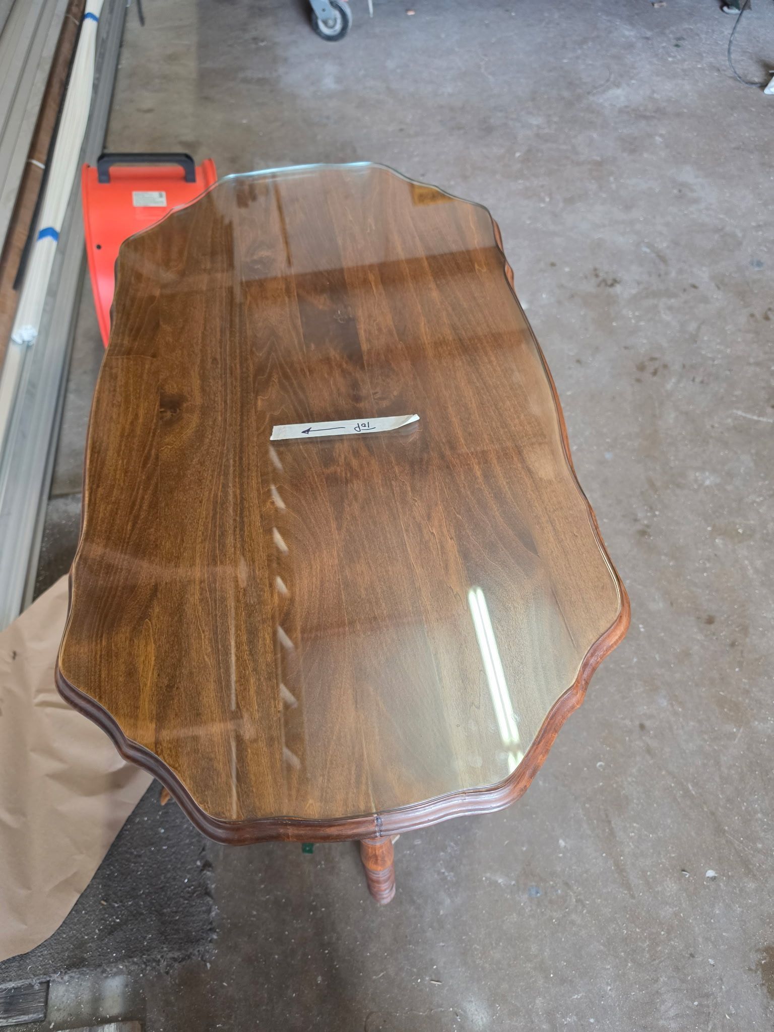 Wooden oval table with a silver handle in a garage or workshop area