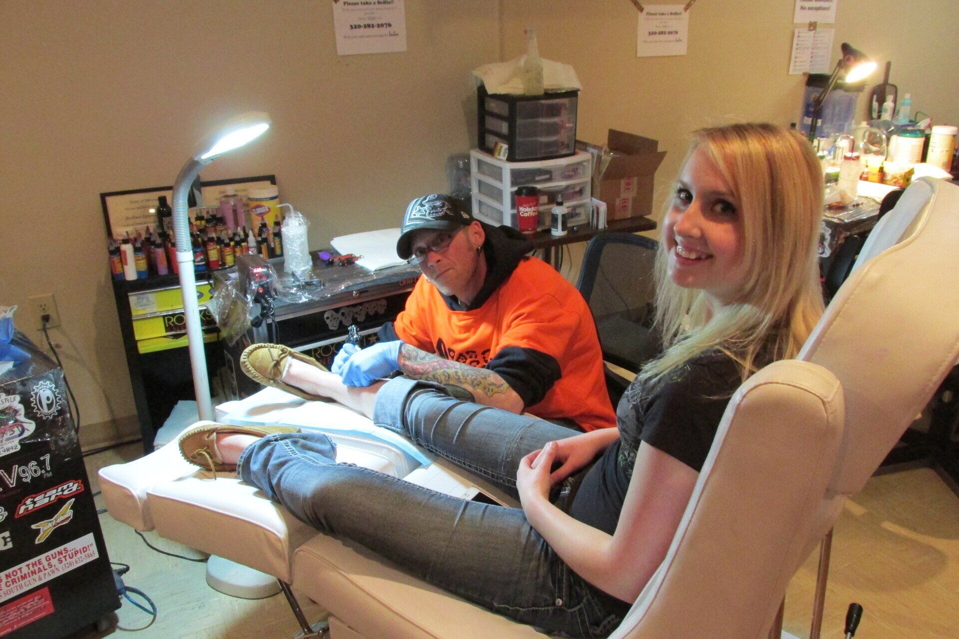 Woman having a tattoo at her legs