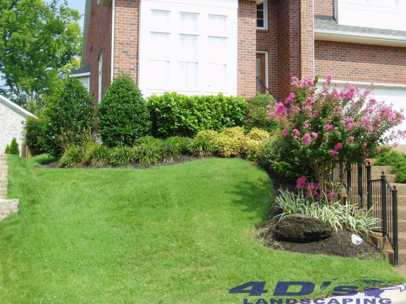 A lush green lawn in front of a brick house