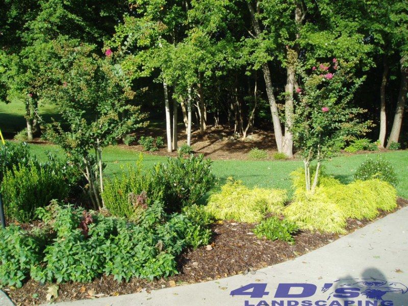 A sign for 4d 's landscaping is on the sidewalk