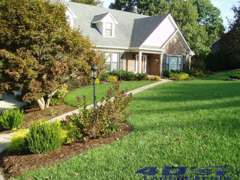 A large house with a lush green lawn and trees