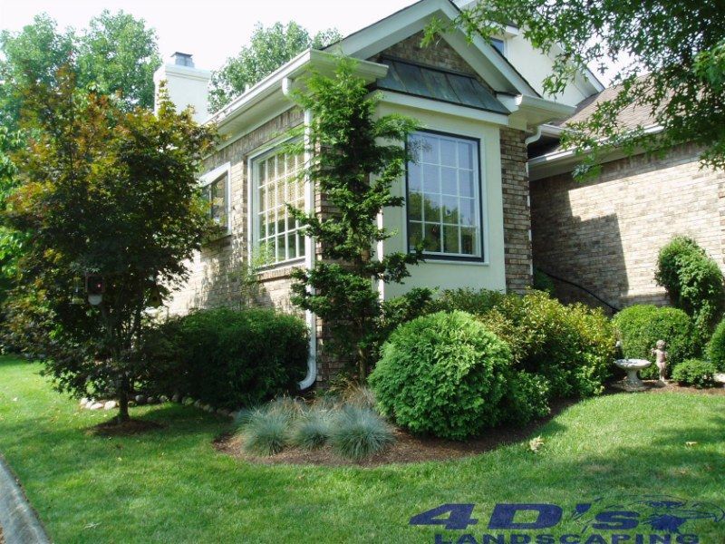 A 4d 's landscaping logo is on the side of a house