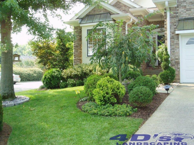 A 4d 's landscaping logo is on the side of a house