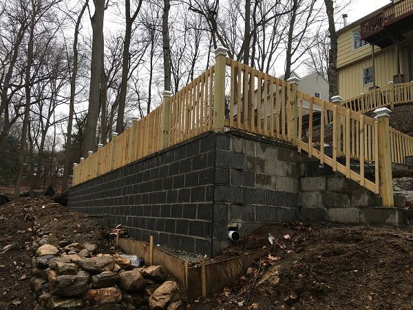 A wooden deck is being built on top of a brick wall.