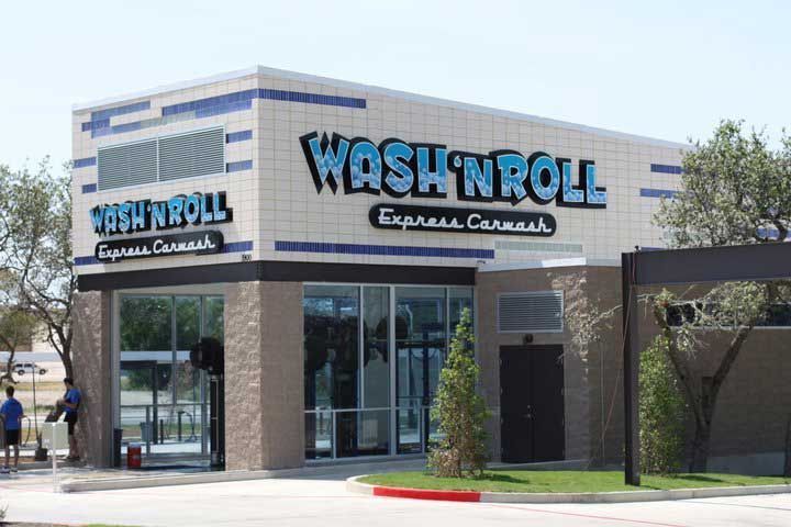 Wash 'N Roll Express Carwash building with a beige and blue facade on a sunny day.