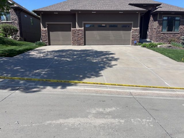 Suburban house driveway with yellow caution tape across the front edge