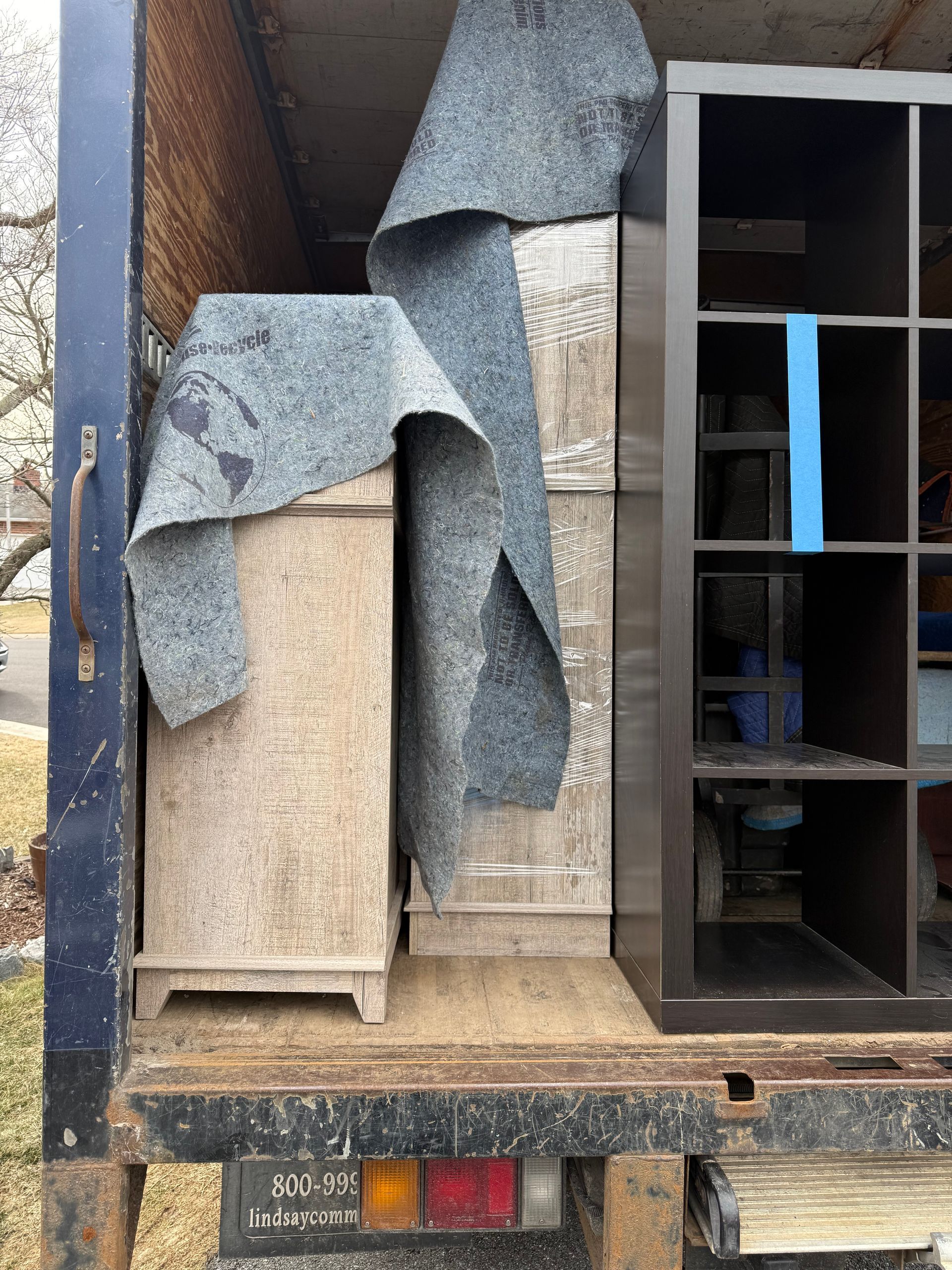 The back of a truck filled with furniture and blankets.