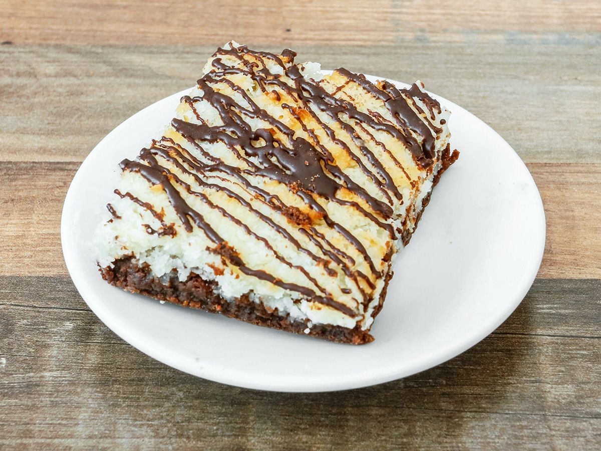 A piece of cake on a white plate on a wooden table.