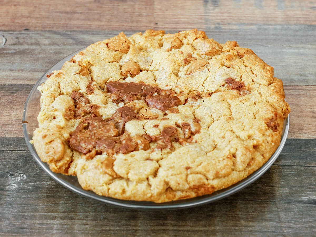 A pie is sitting on a plate on a wooden table.