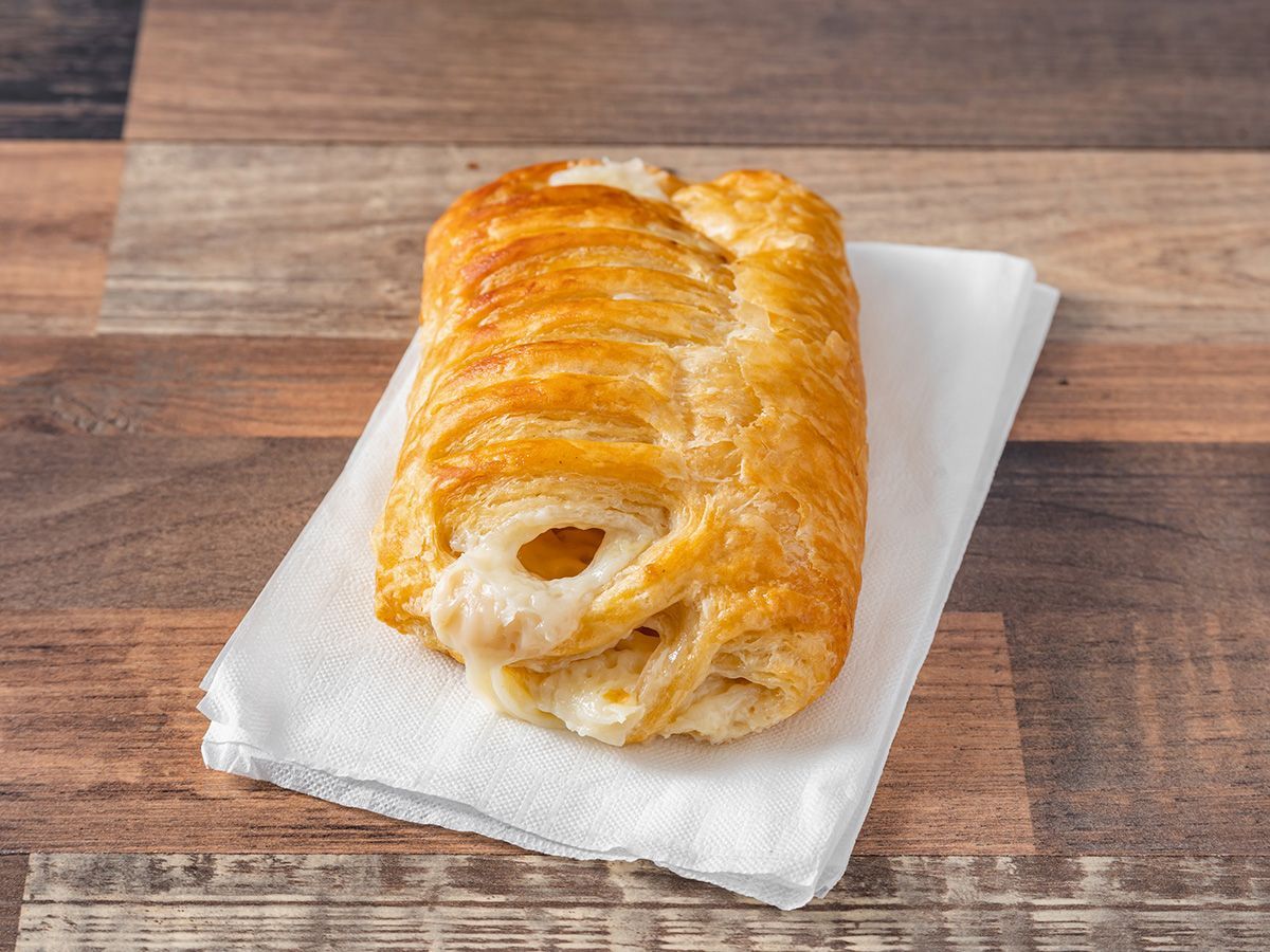 A pastry is sitting on a napkin on a wooden table.