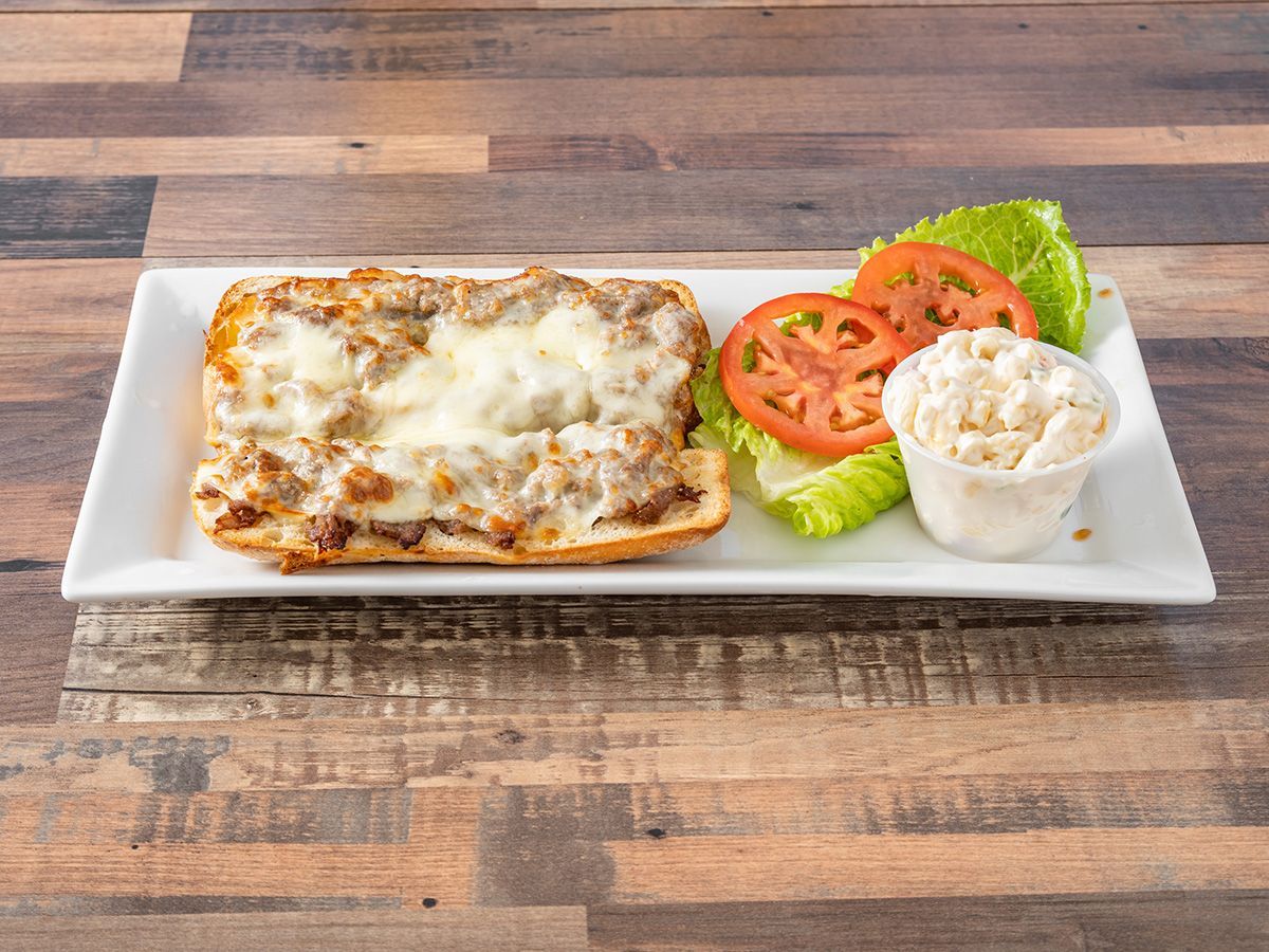 A white plate topped with a sandwich, lettuce, tomatoes and a cup of mashed potatoes.