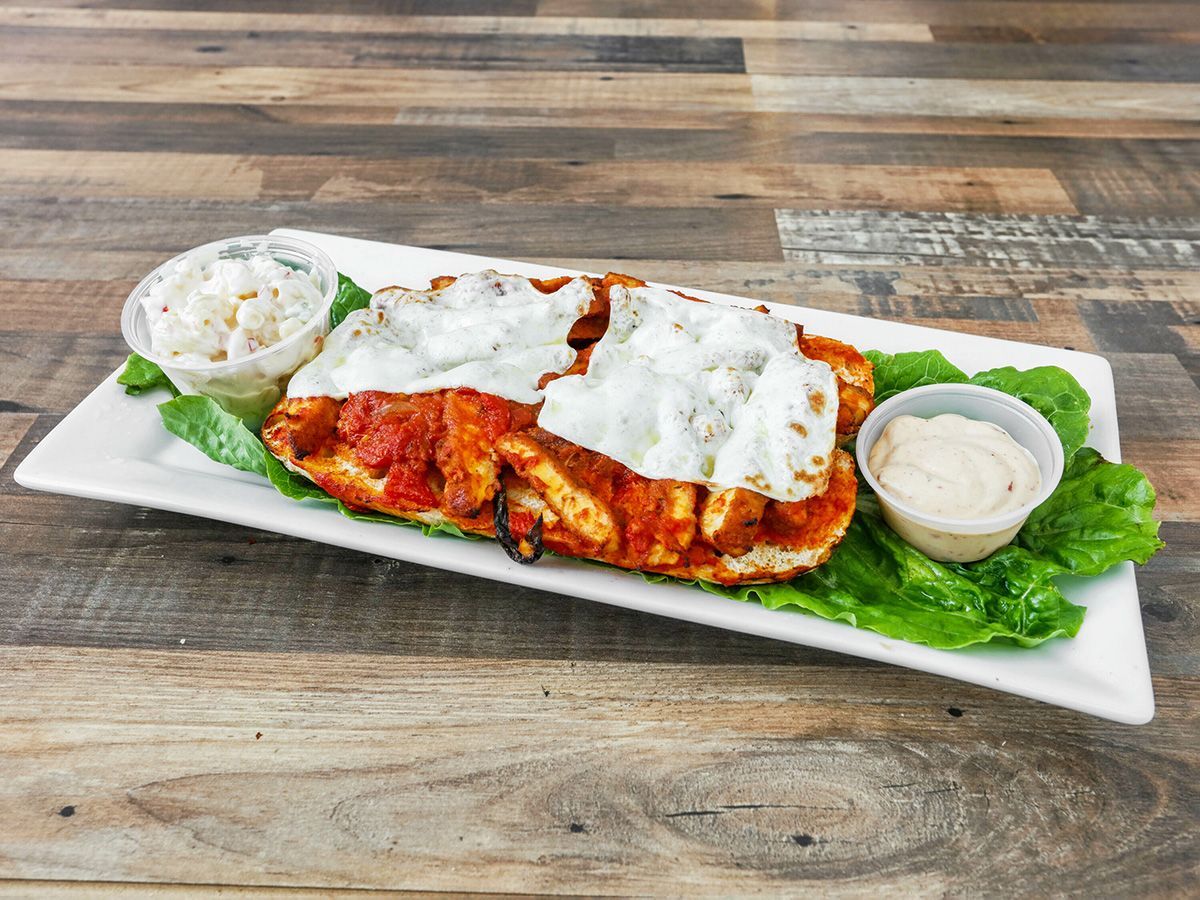 A white plate topped with a piece of chicken covered in sauce and cheese.