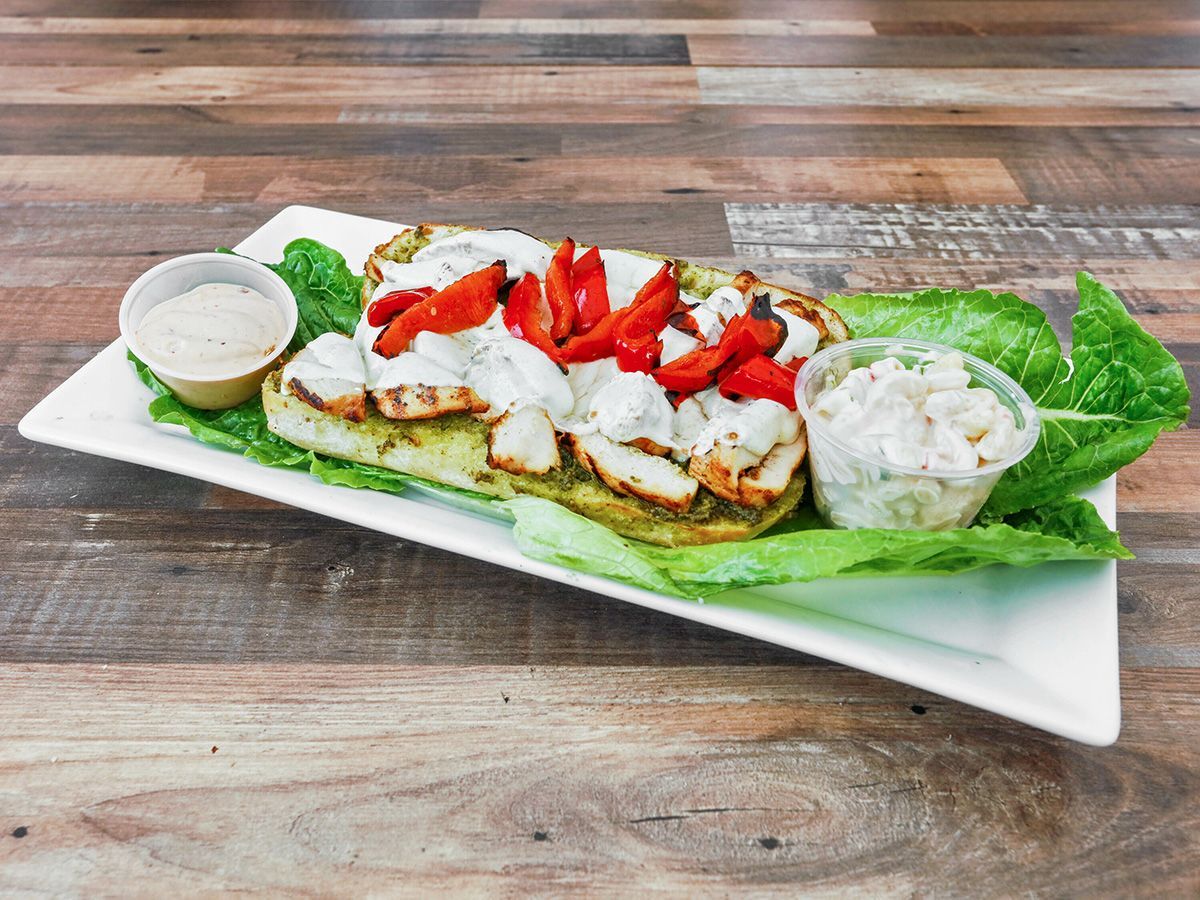 A white plate topped with a sandwich and lettuce on a wooden table.