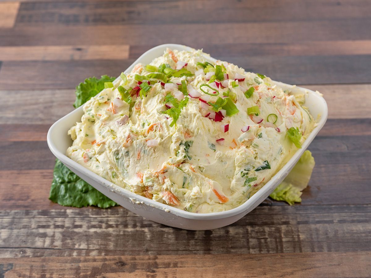 A bowl of potato salad on a wooden table.